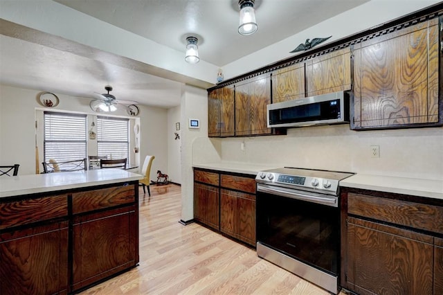 kitchen featuring light countertops, a ceiling fan, light wood-type flooring, and stainless steel appliances