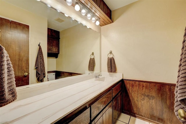 bathroom with a wainscoted wall, visible vents, wood walls, tile patterned flooring, and vanity