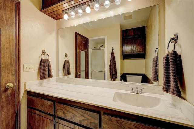 full bath featuring a shower stall, vanity, and toilet