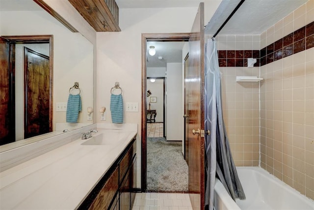 bathroom featuring tile patterned floors, shower / bath combo with shower curtain, and vanity