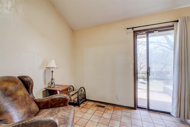 sitting room with visible vents, lofted ceiling, baseboards, and light tile patterned flooring