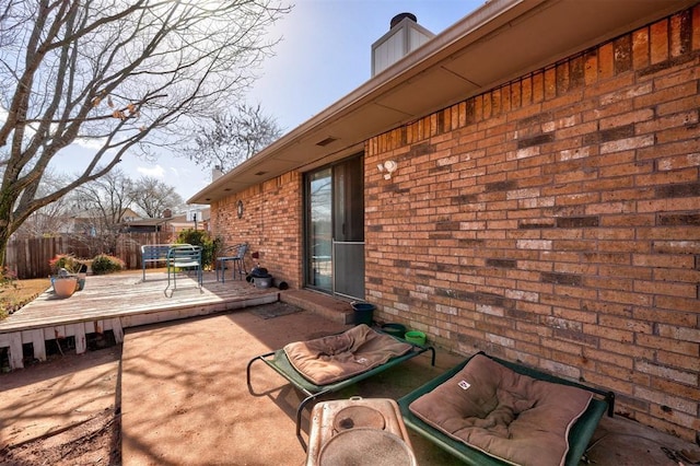 view of patio featuring a wooden deck and fence