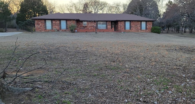 view of front of house featuring gravel driveway and brick siding