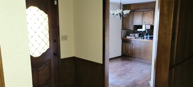 interior space with pendant lighting, wood finished floors, and a notable chandelier