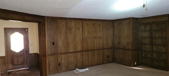 interior space featuring wooden walls and a textured ceiling