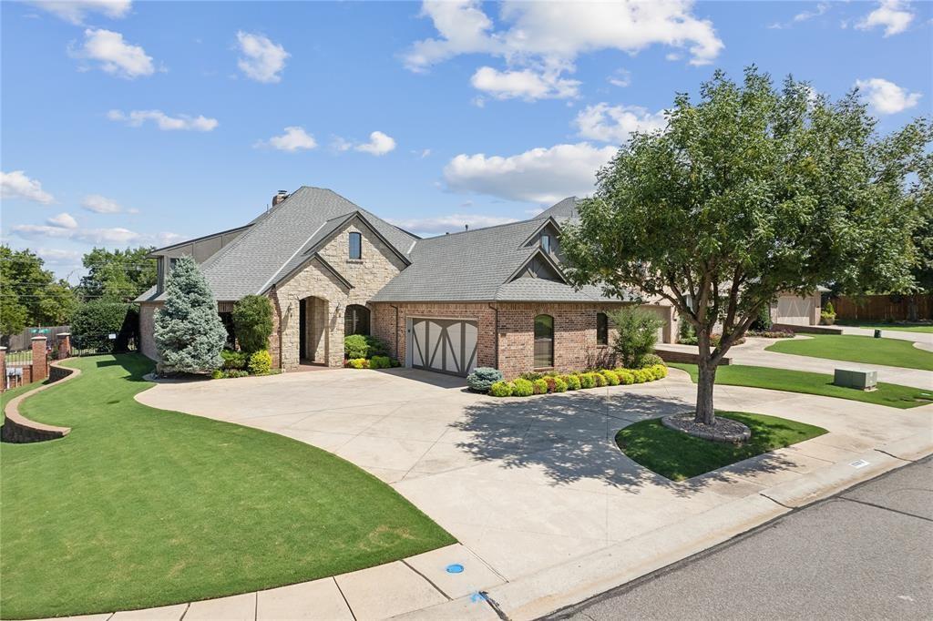 french country inspired facade featuring stone siding, brick siding, driveway, and a front lawn