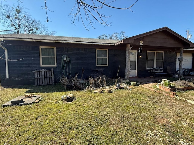 view of front of property with a garage, a front yard, and brick siding