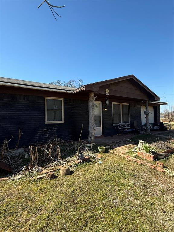 single story home with a front yard, a patio area, and brick siding