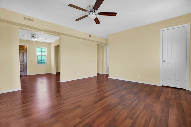 spare room featuring dark wood-style floors, visible vents, and baseboards