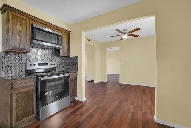 kitchen featuring dark wood-style floors, baseboards, appliances with stainless steel finishes, and decorative backsplash