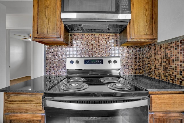 kitchen with dark countertops, electric range, extractor fan, and decorative backsplash