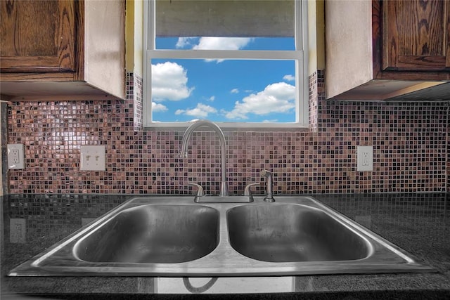 details with dark countertops, decorative backsplash, and a sink