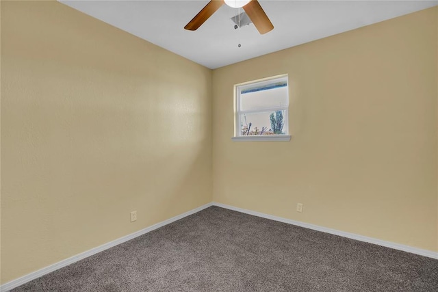 spare room with baseboards, dark carpet, and a ceiling fan