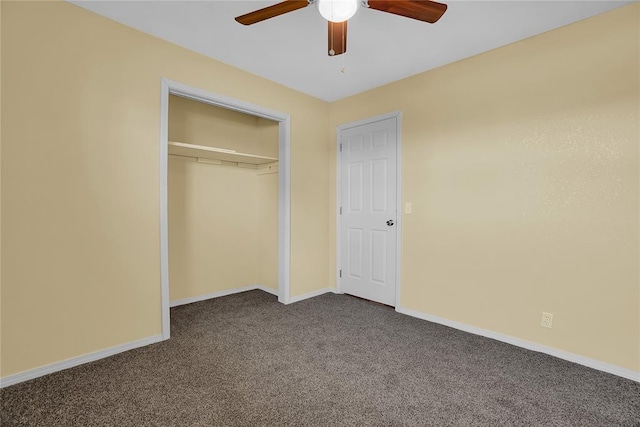 unfurnished bedroom with a ceiling fan, dark colored carpet, a closet, and baseboards