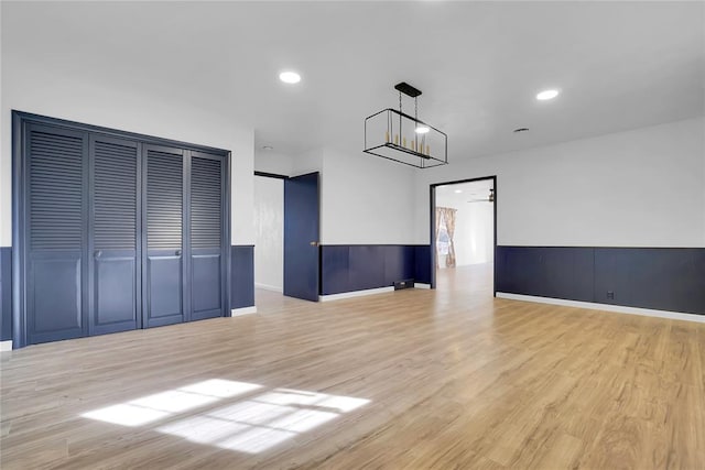 empty room with recessed lighting, a wainscoted wall, and wood finished floors