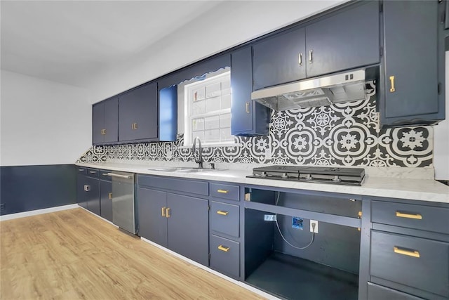 kitchen with light countertops, appliances with stainless steel finishes, a sink, and under cabinet range hood