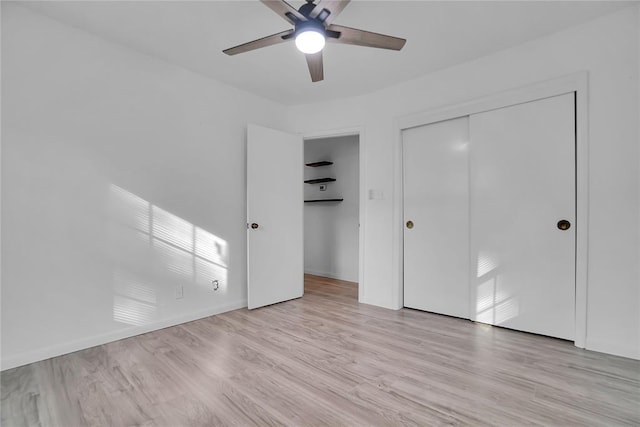 unfurnished bedroom with baseboards, ceiling fan, a closet, and light wood-style floors