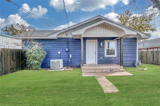 rear view of house with a yard, a fenced backyard, and central air condition unit