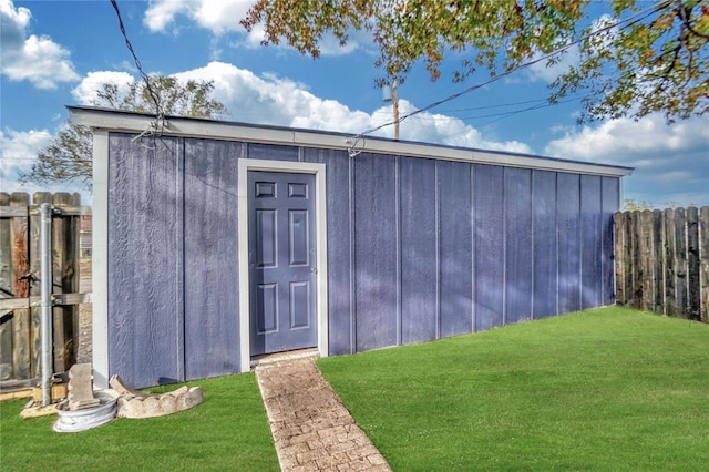 view of outdoor structure featuring fence and an outbuilding