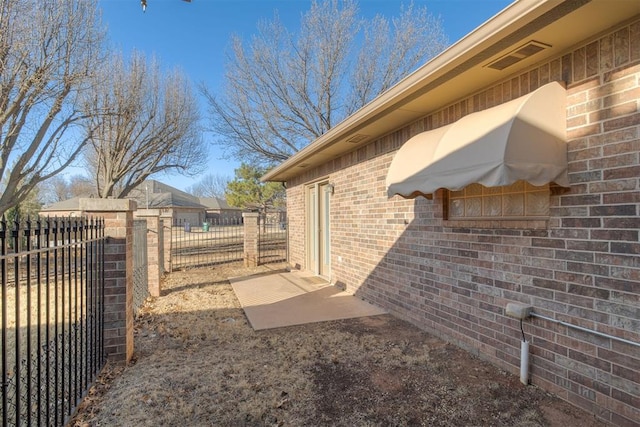 view of property exterior with brick siding and fence