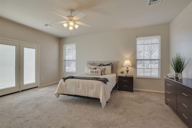 bedroom featuring visible vents, multiple windows, and light colored carpet