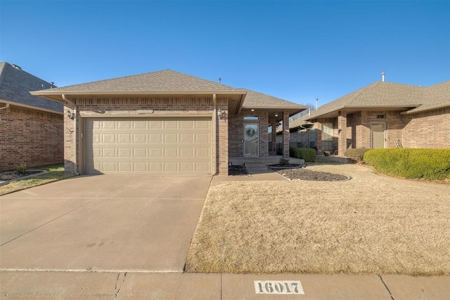 view of front of property featuring concrete driveway, an attached garage, brick siding, and roof with shingles