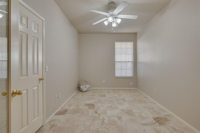 spare room featuring baseboards and ceiling fan