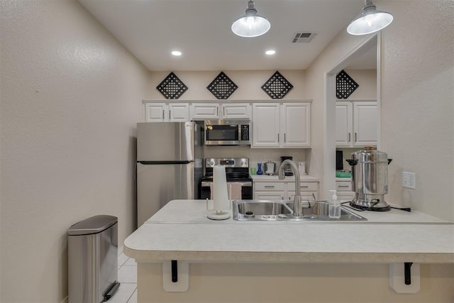 kitchen with visible vents, a sink, light countertops, white cabinets, and appliances with stainless steel finishes