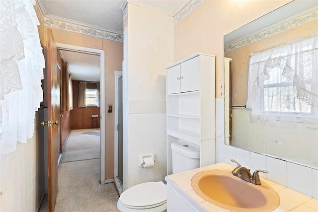 bathroom featuring toilet, a shower stall, tile walls, and a textured ceiling