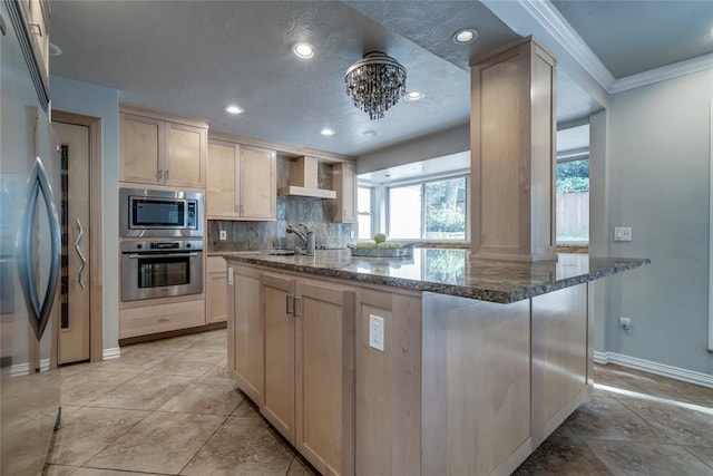 kitchen with appliances with stainless steel finishes, dark stone counters, wall chimney exhaust hood, tasteful backsplash, and crown molding