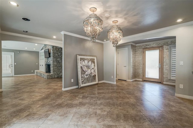 empty room featuring baseboards, crown molding, a stone fireplace, a chandelier, and recessed lighting