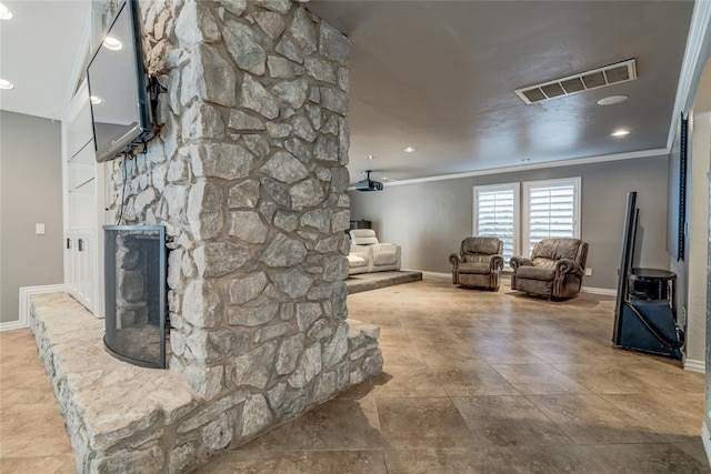 living room featuring baseboards, visible vents, ornamental molding, and a stone fireplace