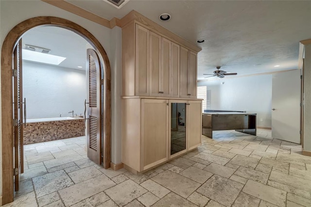 corridor with arched walkways, recessed lighting, baseboards, and stone tile floors