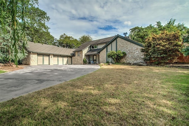 view of front of property featuring a garage, stone siding, a front lawn, and concrete driveway