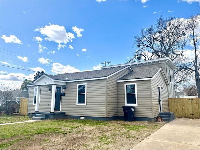 view of front of home featuring a shingled roof, entry steps, and fence