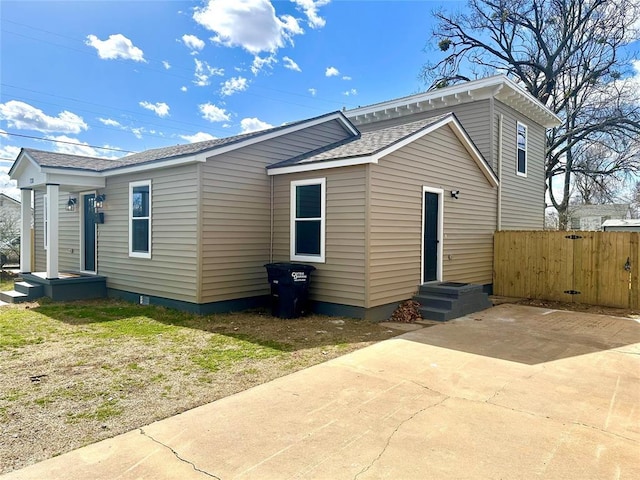 view of front of house with a shingled roof and fence