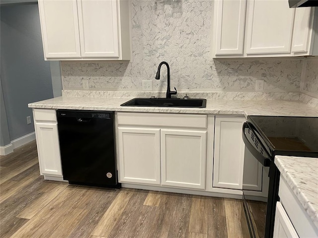 kitchen with white cabinets, black appliances, light wood-style floors, and a sink