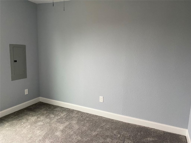 empty room with dark carpet, electric panel, and baseboards