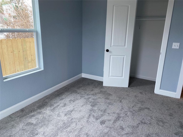 unfurnished bedroom featuring a closet, carpet, and baseboards