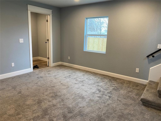 empty room featuring carpet floors and baseboards