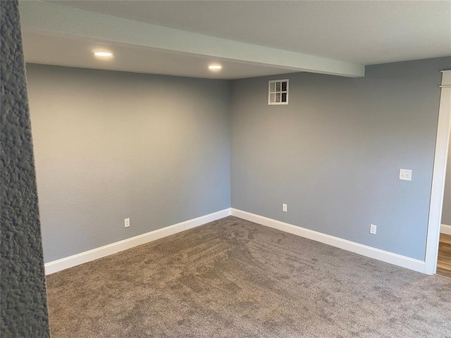 finished below grade area with dark colored carpet, visible vents, baseboards, and recessed lighting