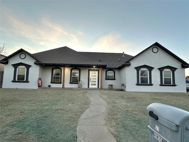 view of front facade with a front yard and stucco siding