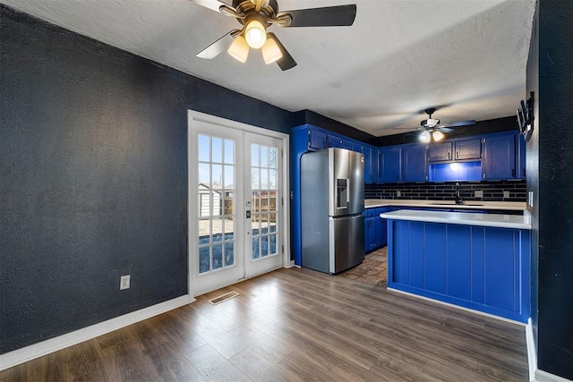 kitchen with visible vents, stainless steel fridge with ice dispenser, blue cabinets, light countertops, and a sink