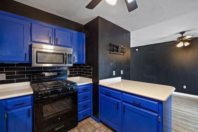 kitchen with a peninsula, blue cabinets, stainless steel microwave, and black gas range oven