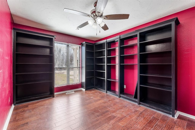 unfurnished room featuring wood finished floors, a ceiling fan, and baseboards