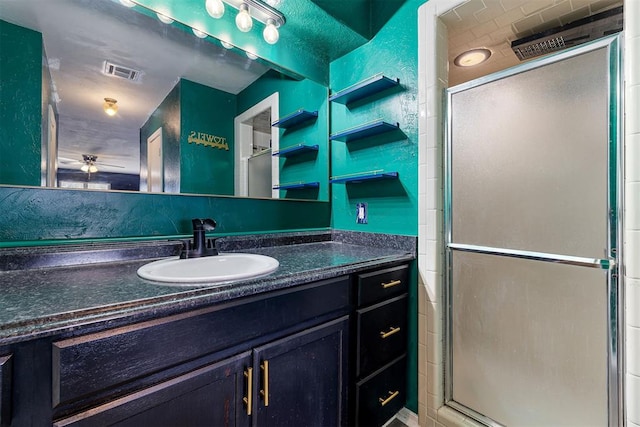 full bathroom with a stall shower, visible vents, a textured wall, and vanity