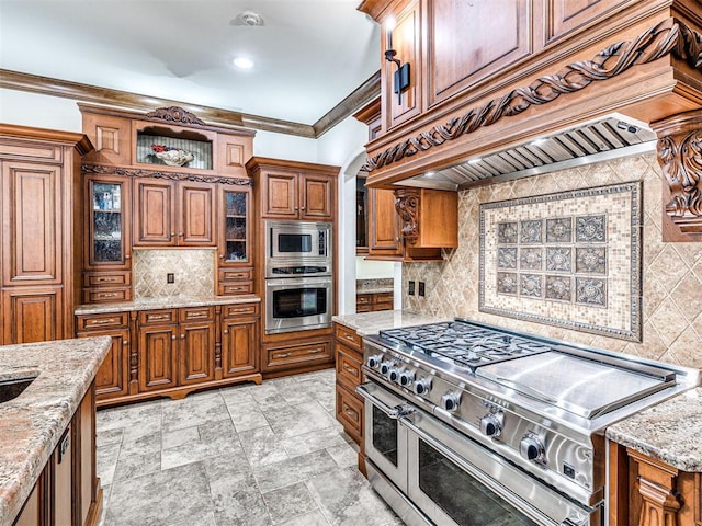 kitchen featuring brown cabinets, stainless steel appliances, custom range hood, backsplash, and ornamental molding