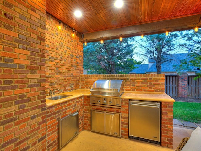 view of patio featuring exterior kitchen, a sink, area for grilling, and fence