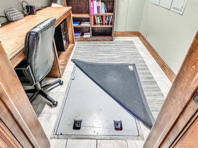 home office featuring baseboards and a textured wall