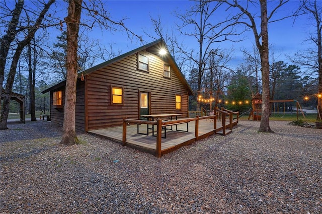 view of home's exterior featuring a playground and a wooden deck